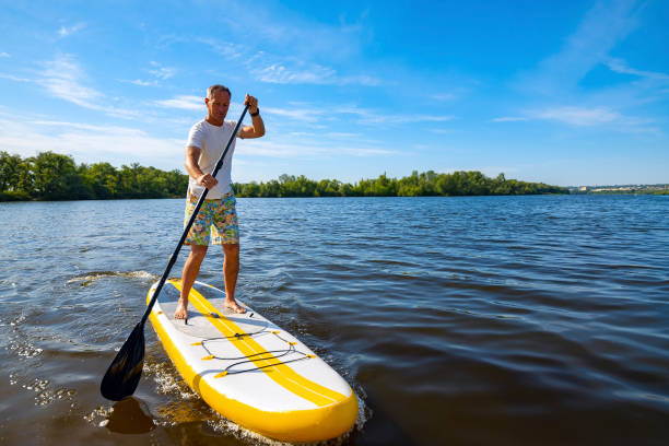 istock Happy man is paddling on a SUP board 1094866974