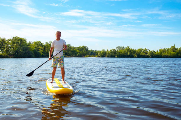 istock Happy man is paddling on a SUP board 1094866976