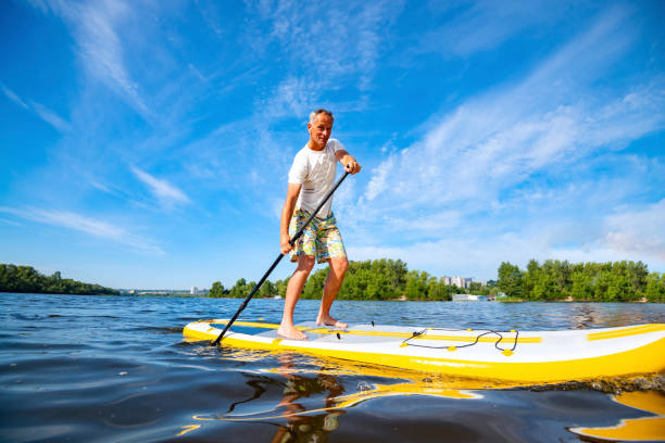 istock Happy man is paddling on a SUP board 1094866980