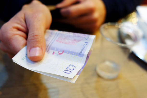 istock man paying the bill with pounds sterling 1094869782