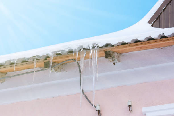 istock Icicles hanging on the roof under the bright sunrays of spring. 1094871342