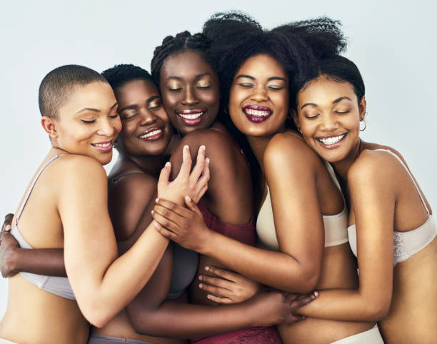 Embracing each other's unique beauty Studio shot of a group of beautiful young women posing together in their underwear against a grey background black skin stock pictures, royalty-free photos & images