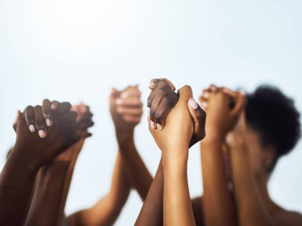 We should lift each other up as women Studio shot of unrecognizable women holding hands huddled together against a grey background womens rights stock pictures, royalty-free photos & images