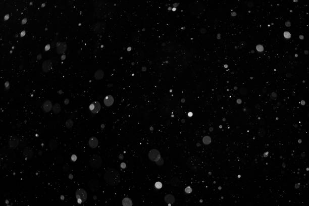 istock a bokeh of white snow on a black background 1094877694