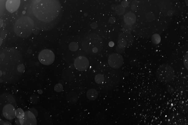 istock a bokeh of white snow on a black background 1094877726