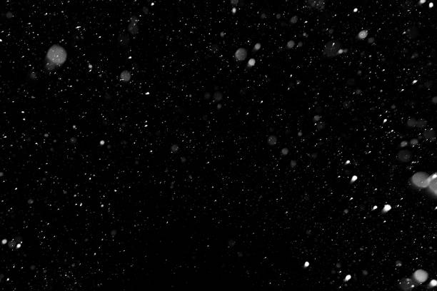 nieve de bokeh blanco sobre un fondo negro de la noche - overlapping fotografías e imágenes de stock