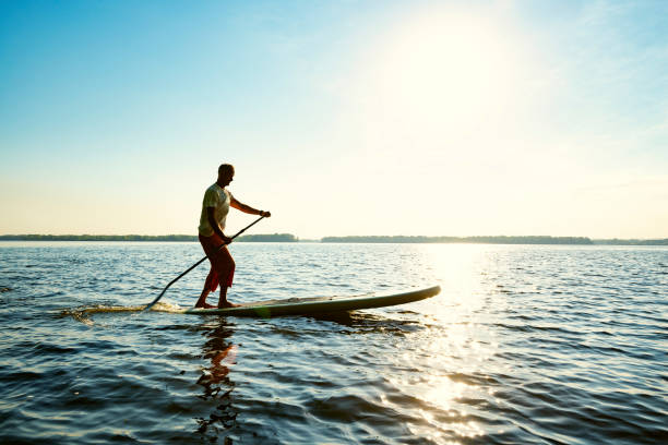 istock Joyful  guy paddling on a SUP board 1094891638