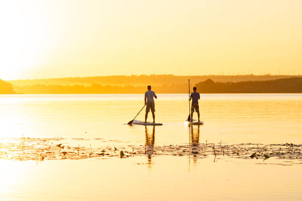 istock Men, friends paddling on a SUP boards 1094891666