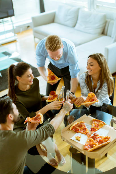 istock Young people eating pizza and drinking cider in the modern interior 1094894524