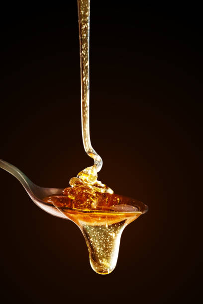 istock Honey with gold color flows down from a spoon, on a dark background. Healthy eating. Diet. Selective focus. 1094894566