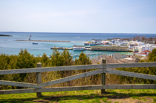 Mackinaw Island, Michigan, USA - May 6, 2015: Mackinaw Island as seen from the water of the Straits Of Mackinaw. With a ferry boat in the foreground and the Grand Hotel on the coast, the Island is a popular vacation destination in the Midwest.