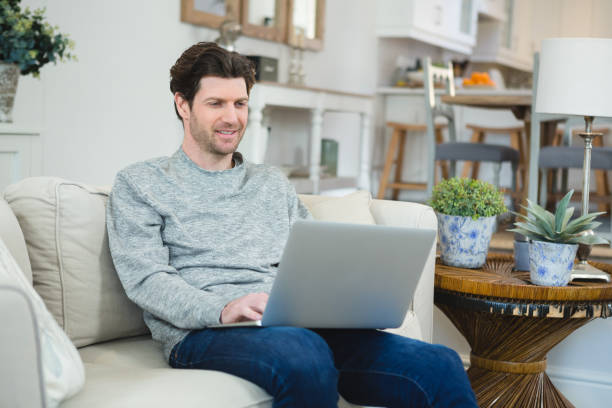istock Man using laptop in living room 1094909958