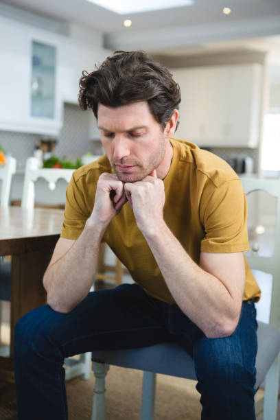 istock Worried man sitting at home 1094910114