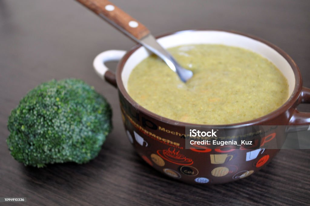 brown plate with broccoli cream soup and a sprig of fresh broccoli Broccoli Stock Photo