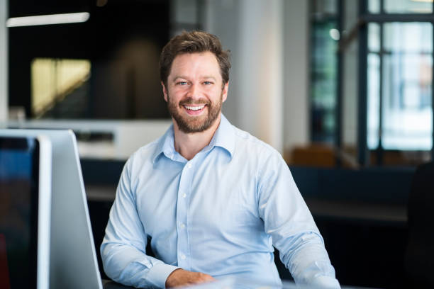 istock Smiling male entrepreneur sitting at new office 1094912302