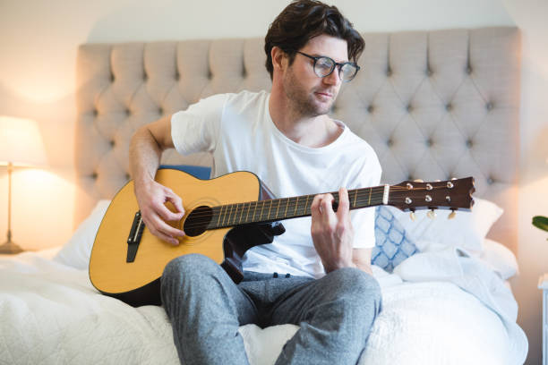 istock Man playing guitar in bedroom 1094912688