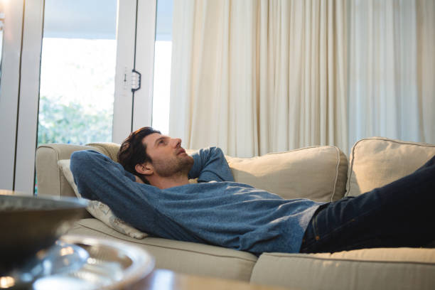 istock Man relaxing on sofa in living room 1094914422