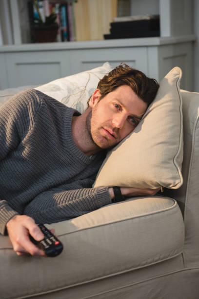istock Man watching television in living room 1094914746