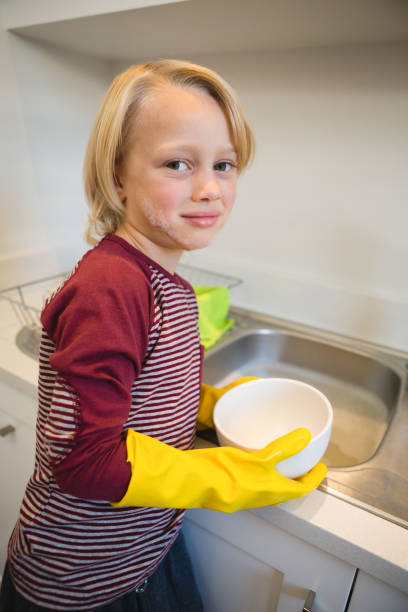 istock Boy washing utensil in kitchen 1094915004
