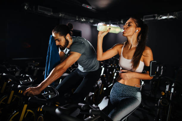 istock Young couple exhausted from working out on exercise bike 1094916282