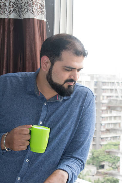 istock Man leaning on balcony drinking coffee in morning 1094916440