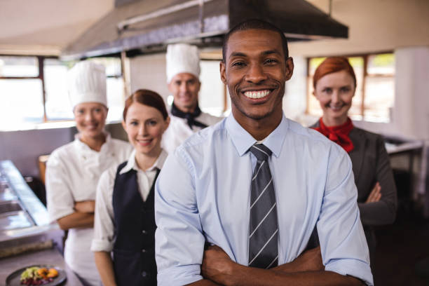Group of hotel staffs standing with arms crossed in kitchen stock photo