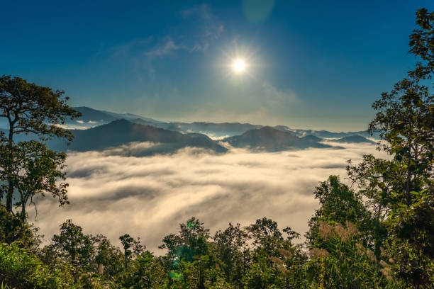 Sunrise over the mountain view fog moving in the morning with sun rays stock photo