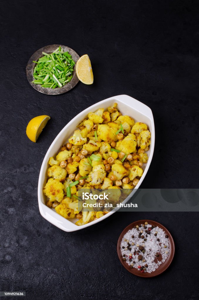 Slices of roasted cauliflower Slices of roasted cauliflower with chickpeas and spices. Selective focus. Appetizer Stock Photo