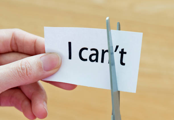 istock Woman hand holding scissors cutting word 'I can't' 1094922178