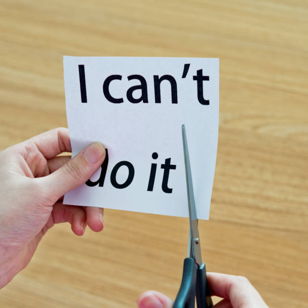 istock Human hand cutting word on paper can't become i can 1094922334