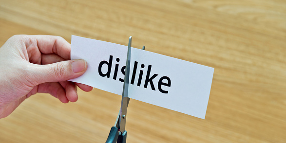 Human hand cutting the dislike word.