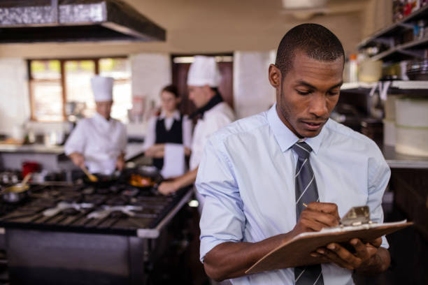 istock Male manager writing on a clipbaord in kitchen 1094922466