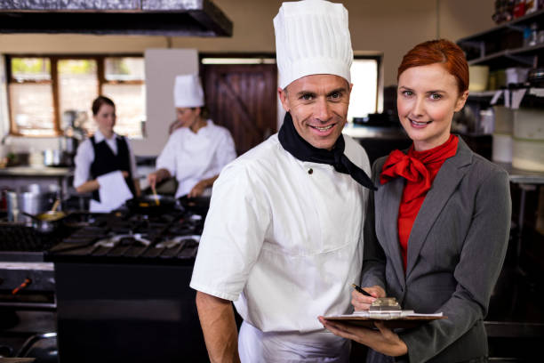 istock Female manager and male chef writing on clipboard in kitchen 1094922866