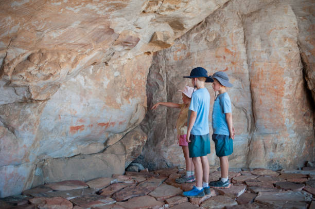 Appreciating the Busman Cave Art Two young boys and their sister pointing looking at traditional Busman paintings in a cave in the Cederberg South Africa cave painting photos stock pictures, royalty-free photos & images
