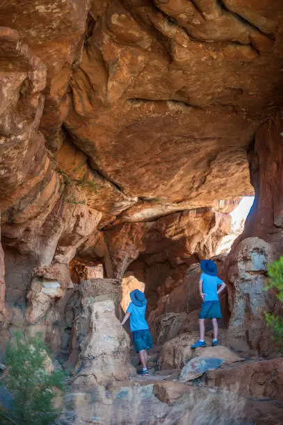 Photo of Two boys in a sandstone cave looking at it