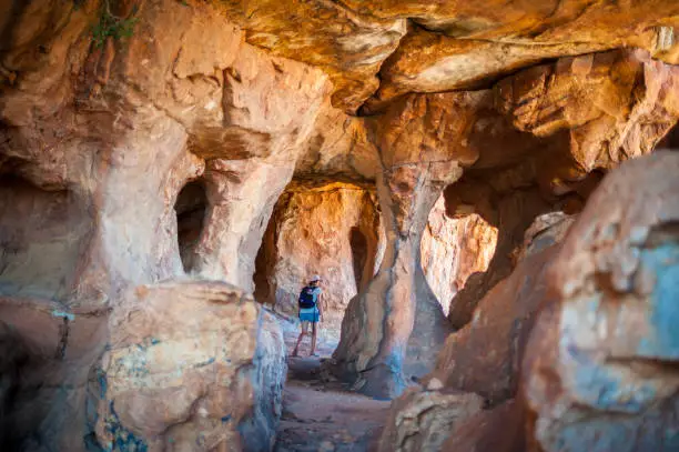 Woman walking through a sandstone cave at Truitjieskraal in the Cederberg Wilderness Area South Africa