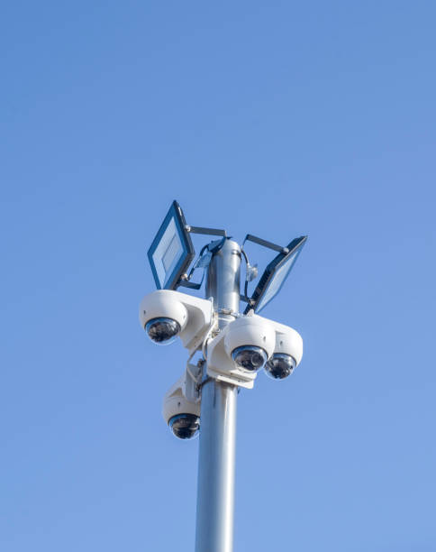 istock Four CCTV dome security cameras and two LED floodlight on a pole in sky 1094949762