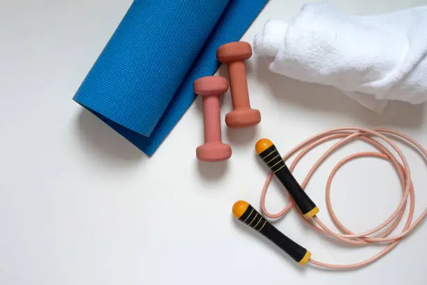 jump rope, yoga mat, dumbbells, white bath towel, close-up on a white background