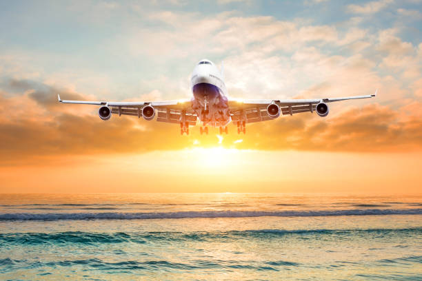 istock Airplane flies over the ocean during landing at sunset. 1094955086