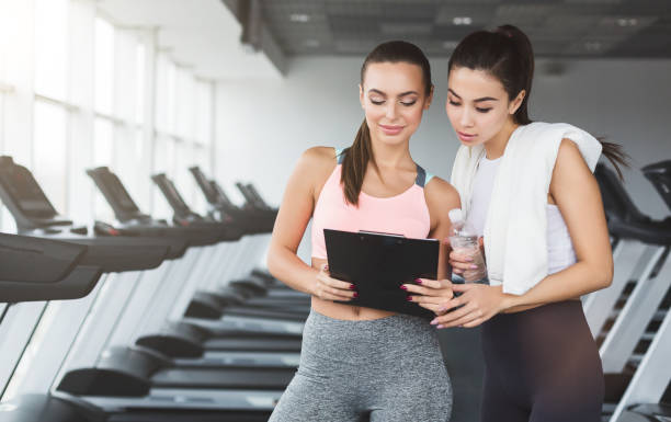 istock Woman and personal trainer writing exercise plan 1094959962