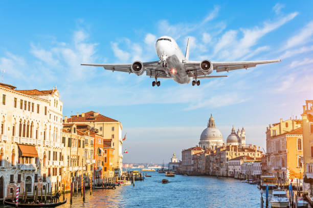 大運河と空を飛んでいる飛行機を見る。イタリア旅行の概念 - venice italy ストックフォトと画像