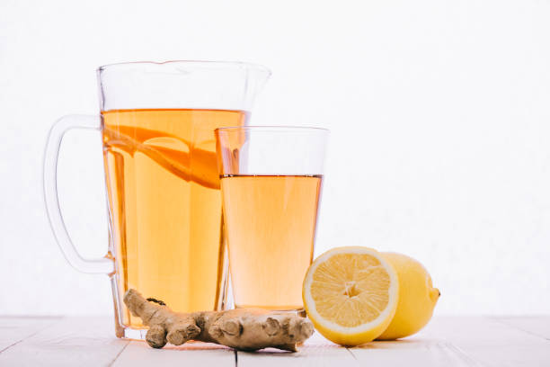 istock tea with lemon and ginger root in glass and jar on wooden table isolated on white 1094963006