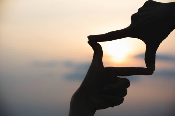 istock Hands making frame with sunset. Close up of woman hands making frame gesture. 1094965518