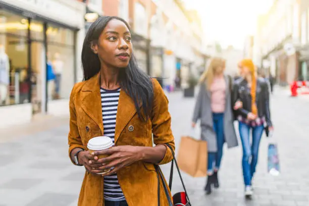 Photo of Black woman walking in the city, shopping theme