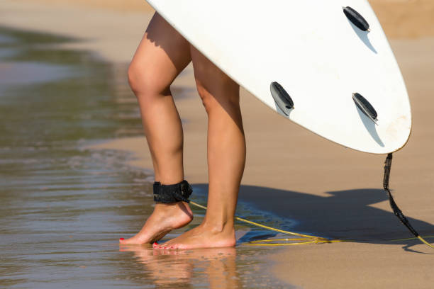 istock Young beautiful surfer girl on beach with surf board at day break 1094970010