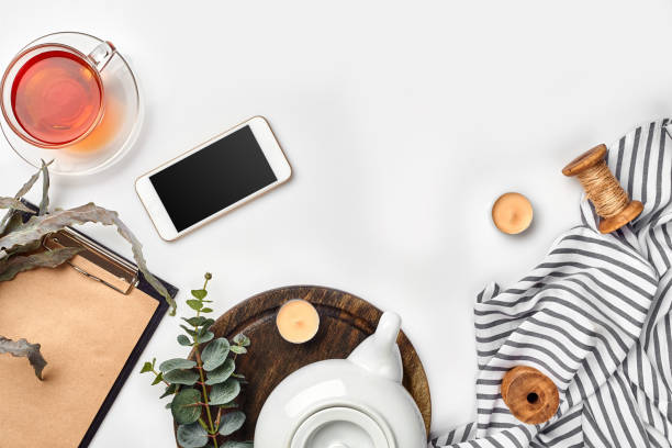 istock Still life with tea cup and the contents of a workspace composed. Different objects on white table. Flat lay 1094974488
