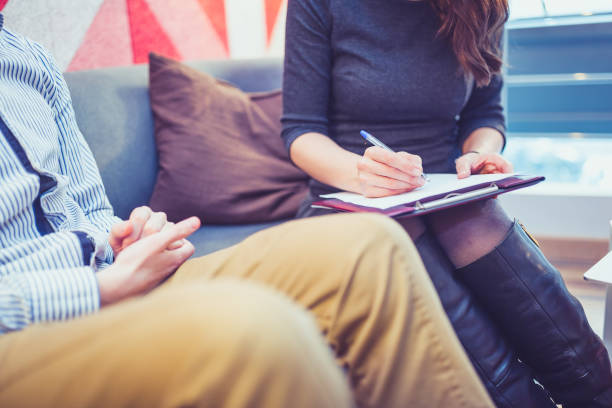 istock Counseling. Therapist talking to young man in therapy session 1094975984