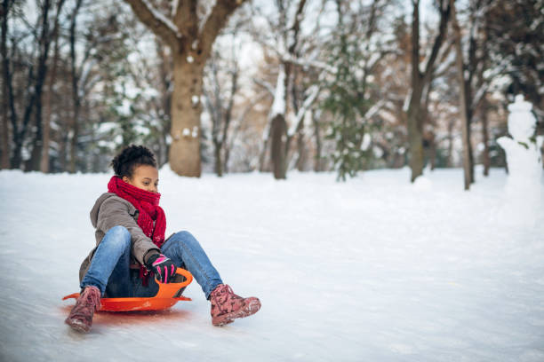 Young girl enjoying tobogganing on a winter day