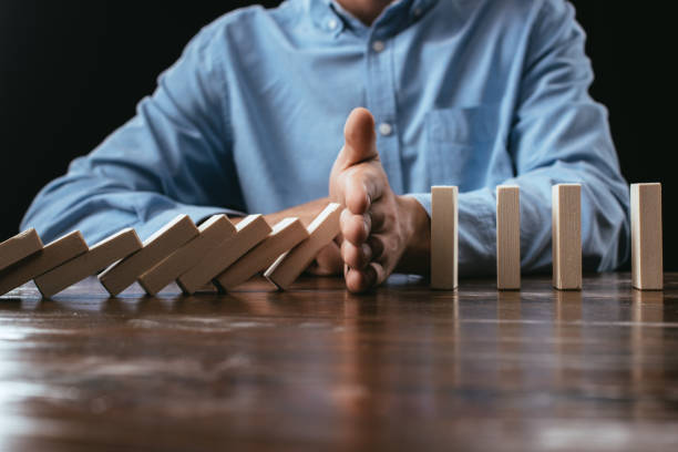 istock selective focus of man preventing wooden blocks from falling 1094978334
