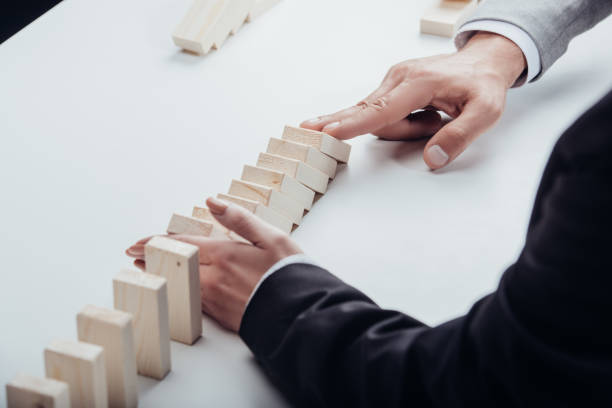 istock partial view of man pushing wooden bricks while woman preventing row from falling 1094979644